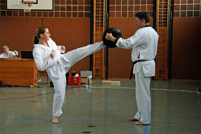 Taekwondo-Schülerin (junge Frau) beim Training der
        Selbstverteidigung bei der Ausführung eines Fußtrittes