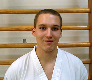 Taekwondo-Trainer Adrian Bell im weißen Trainingsanzug
            (Tobok)