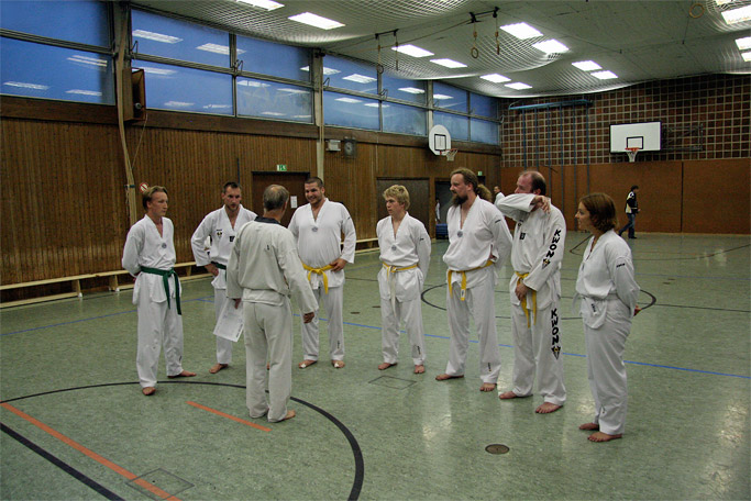 Taekwondo-Training für Erwachsene in der Trainingshalle Bad Tölz bei der der Trainer (Sabum) den Schülern die Theorie erklärt
