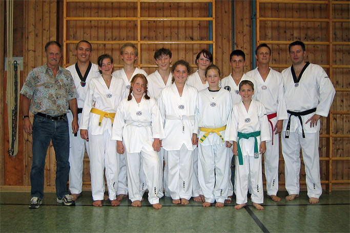 Prüfungs-Foto mit Kindern und Jugendlichen mit
          Taekwondo-Trainer Willi Hobel in der Turnhalle Bad Tölz