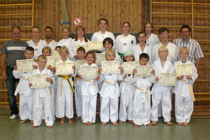 Prüfungsbild mit Taekwondo-Trainer Willi Hobel und
          Kindern und Jugendlichen nach einer Gurtprüfung in der
          Mehrzweckhalle in Bad Tölz