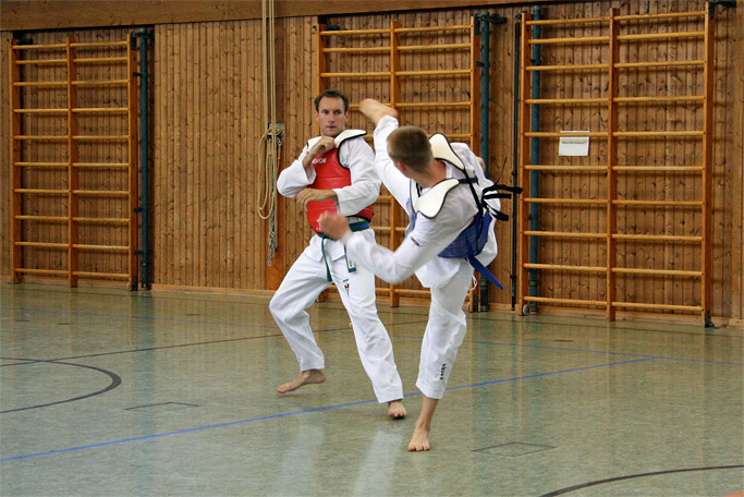 Zwei
        Taekwondo-Schüler mit Westen beim Wettkampf-Training